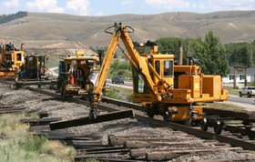 The ties are out from under the rails, but still close to the rails.  The tie crane picks them up and moves them out of the way.  CRW 2578a